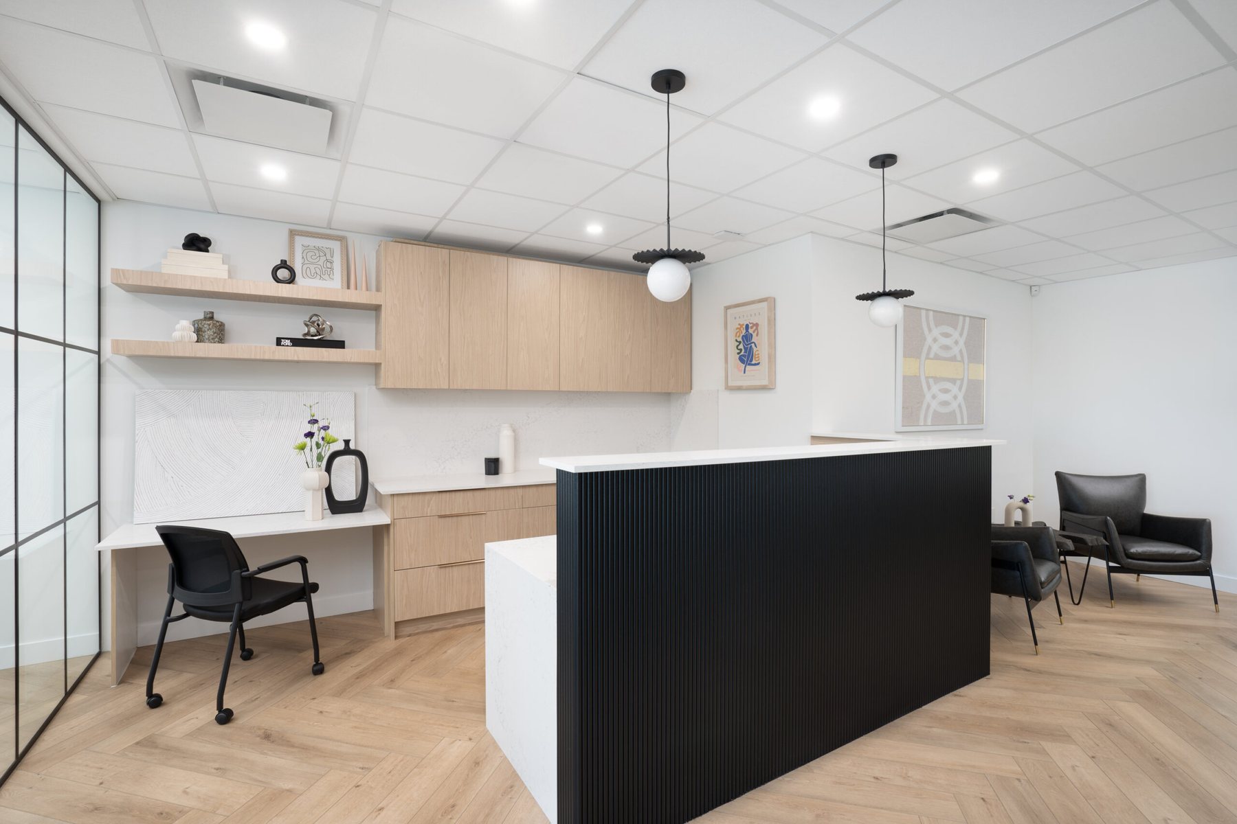 Finished South Surrey office reception with light oak millwork and a black fluted desk